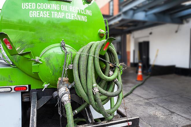 a technician pumping a grease trap in a commercial building in Utica